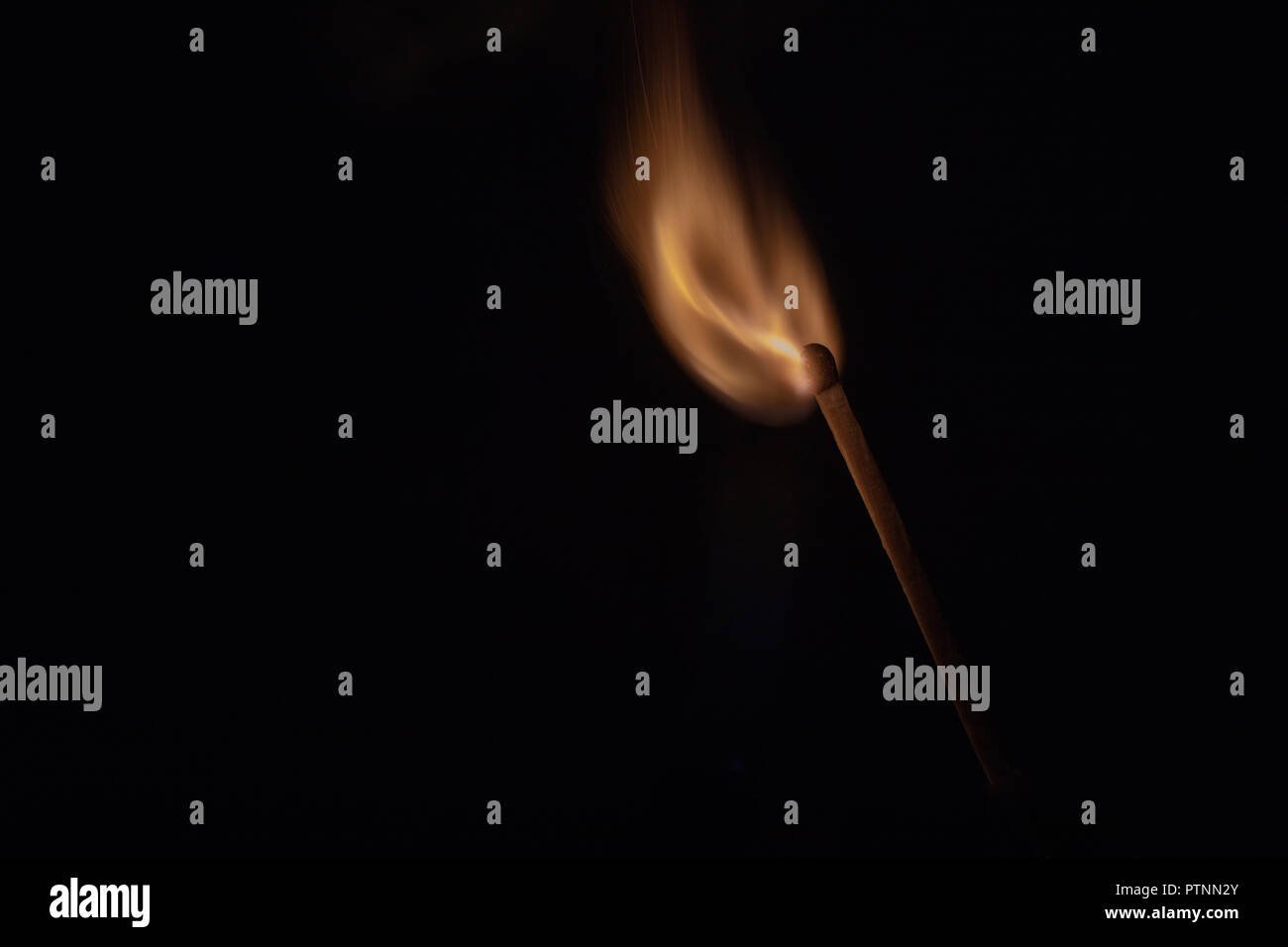 Match with strongly flaring flame on a black background closeup Stock Photo