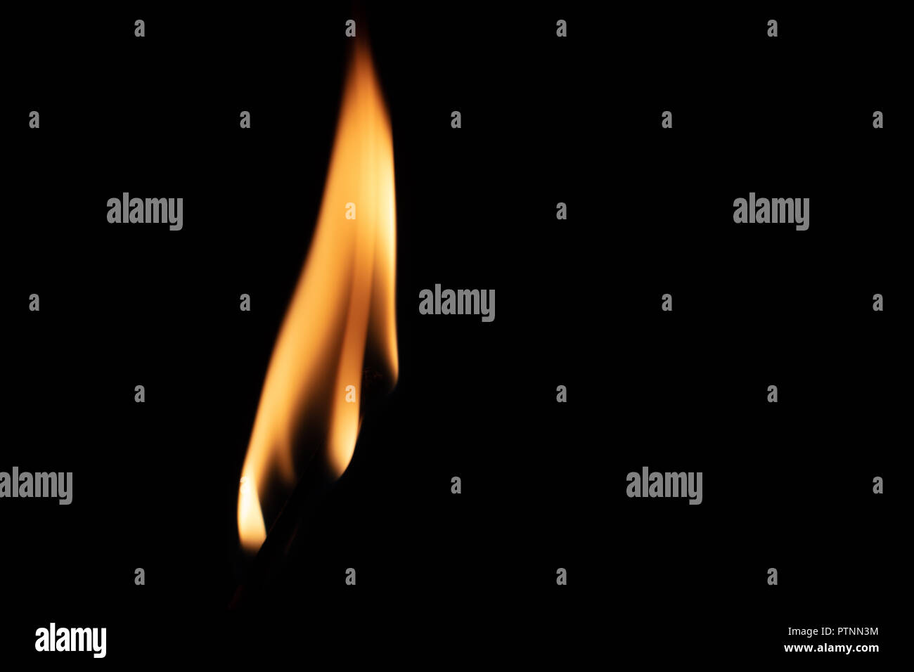 Match with strongly flaring flame on a black background closeup Stock Photo