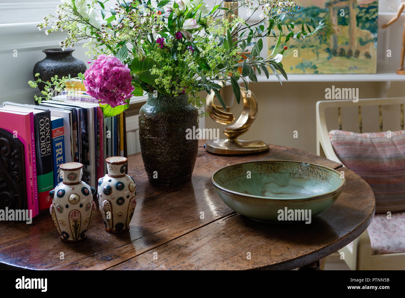 Decorative arrangement of ceramics on the circular drop leaf oak table Stock Photo