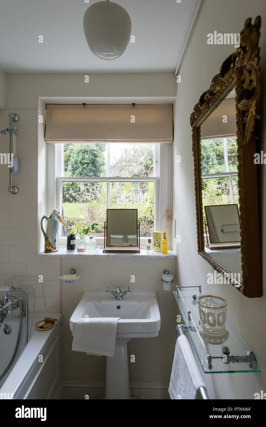 Majolica heron jug on windowsill  Edwardian style bathroom with view to garden Stock Photo