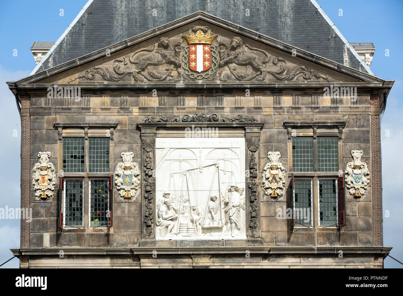 THE NETHERLANDS, GOUDA - OCTOBER 10, 2018: Facade of the famous cheese weighing house with the relief of the weighing process. Stock Photo