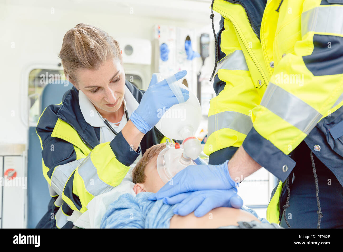 Emergency doctor giving cardiac massage for reanimation in ambulance to