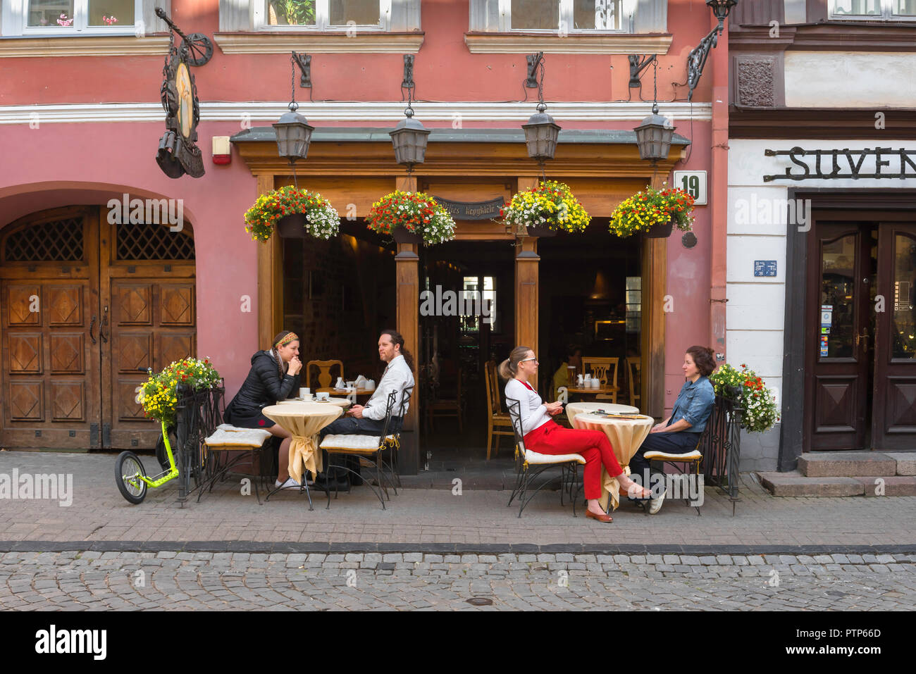 Vilnius old town, view of young people sitting outside a cafe in Pilies Gatve - the main thoroughfare in the center of Vilnius Old Town, Lithuania. Stock Photo