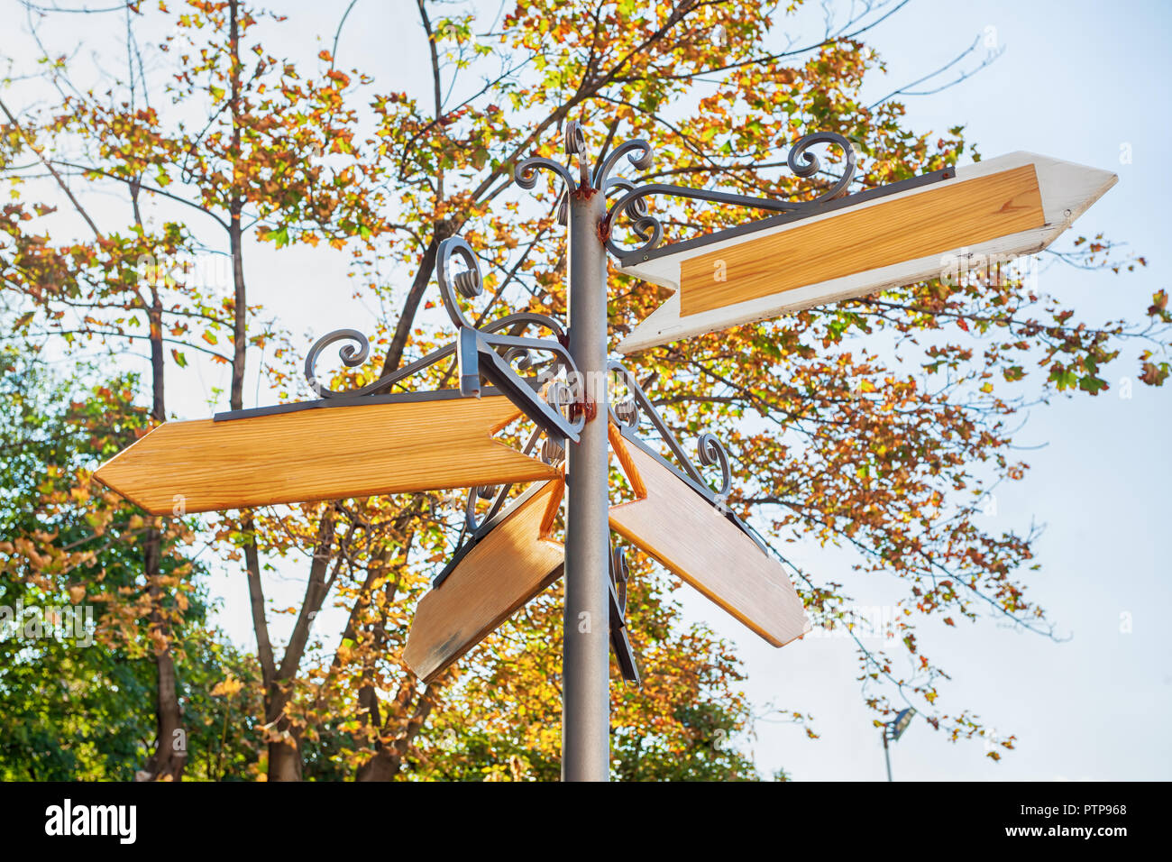 Blank metal and wood signage, empty guidepost, sign on natural background ; multi-direction guidepost Stock Photo