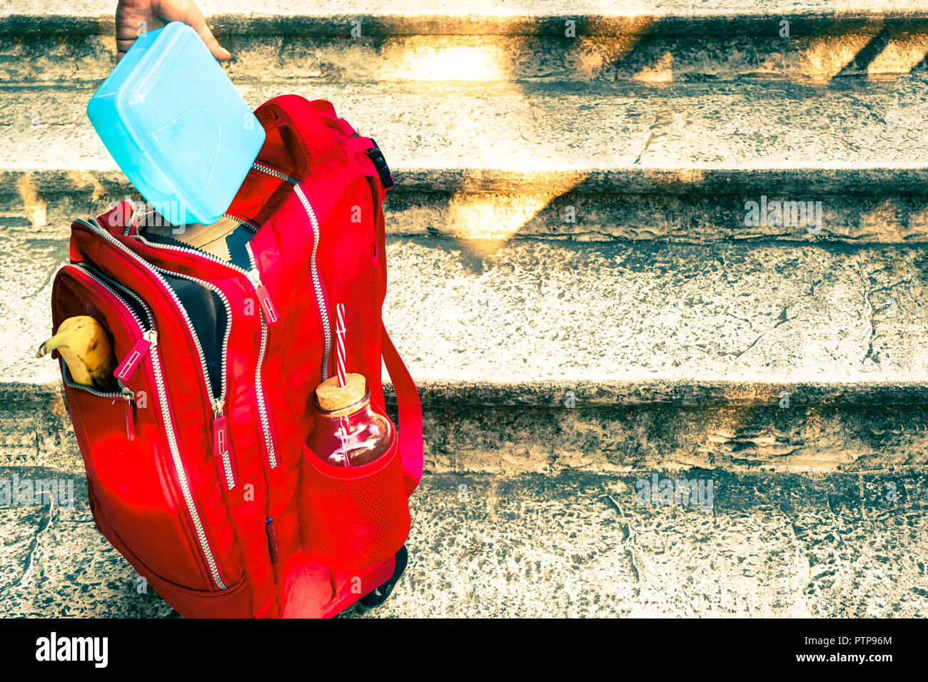 Ready for school putting lunchbox in backpack Stock Photo Alamy