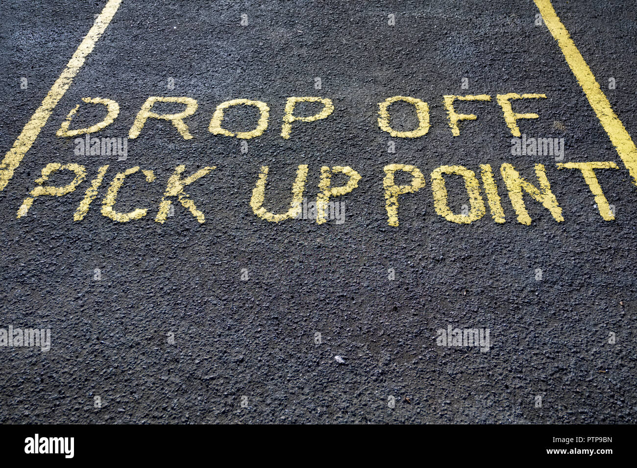 Drop off pick up point parking space sign on black asphalt tarmac in