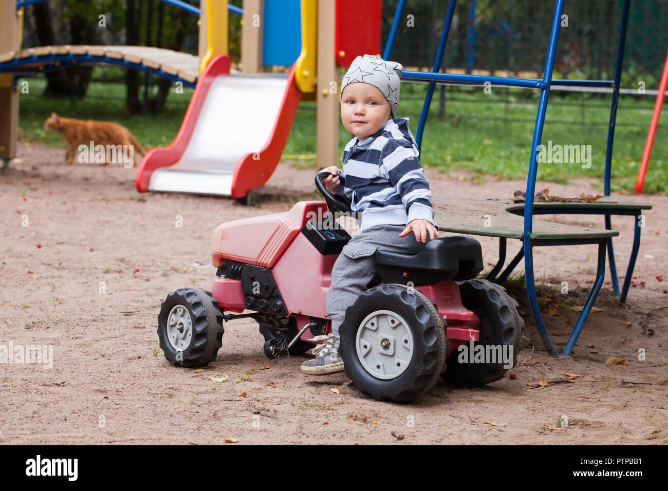 Child driving a car toy on playground Stock Photo Alamy