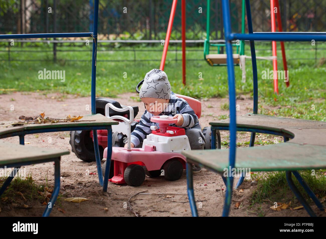 Child playing car toy on playground Stock Photo - Alamy