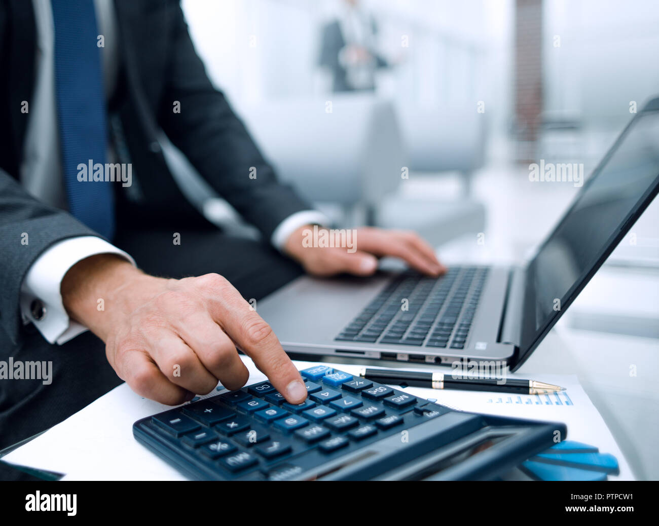 close up.a businessman uses a calculator and a laptop Stock Photo - Alamy