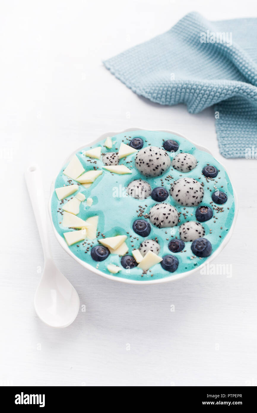 healthy blue spirulina smoothie bowl with blueberry, white chocolate
