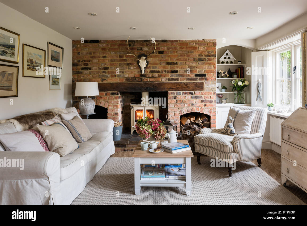 Framed artwork above sofa with ovory woodburner in 18th century Norfolk
