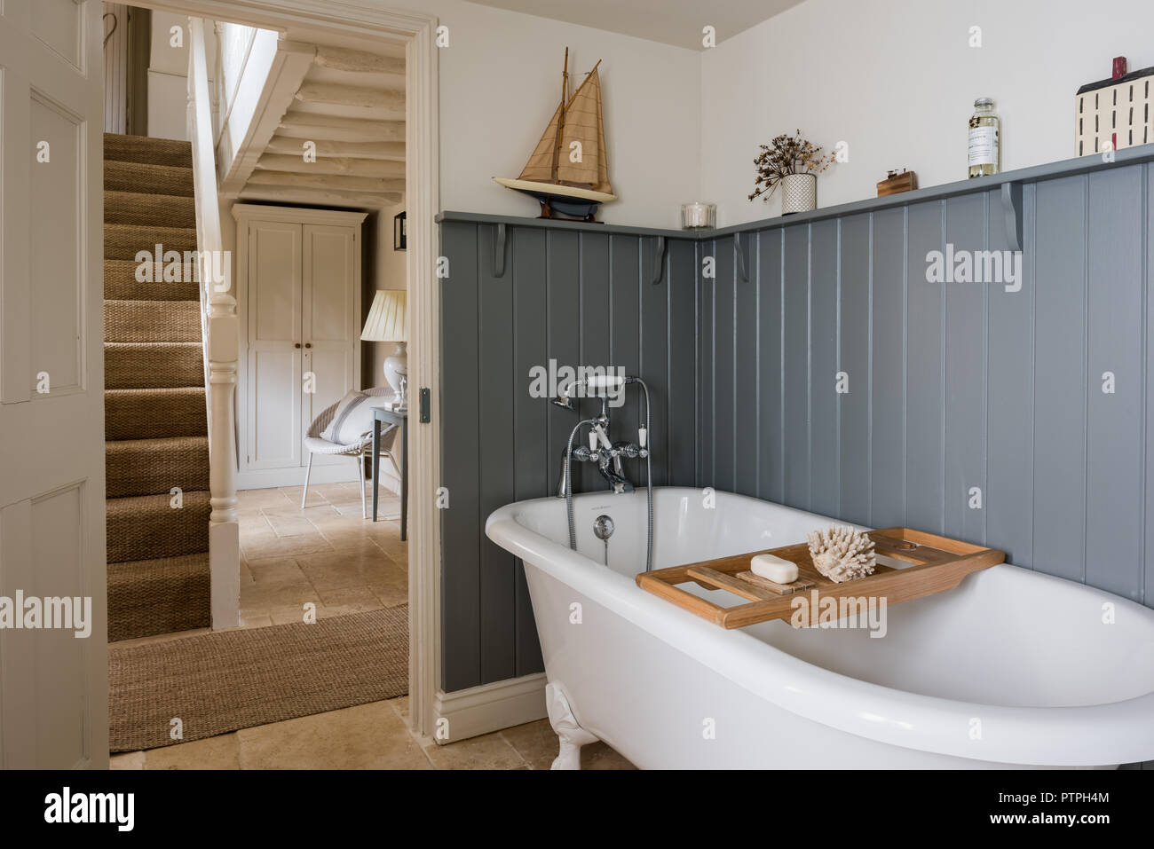 White freestanding bath with rack and ornaments on shelf in 18th century Norfolk cottage Stock Photo