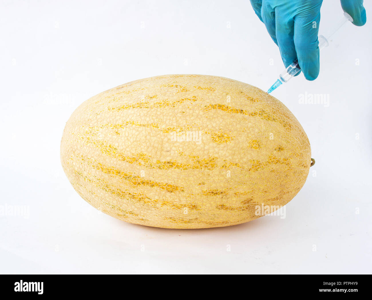 Melon on a white background in which enter gmo and nitrates, close-up, genetically modified organism, melon, nitrates Stock Photo