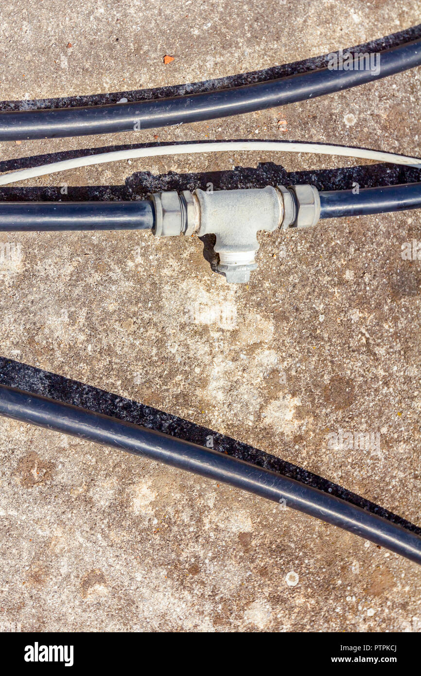 Few black plastic water hoses with bifurcation part are placed on concrete floor Stock Photo Alamy