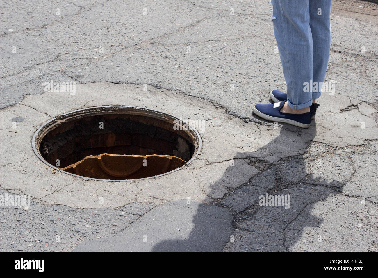 Outdoor sewer and feet in jeans, close-up Stock Photo
