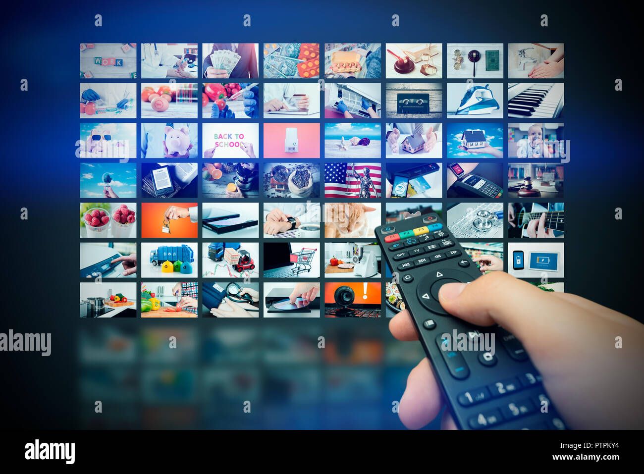 Multimedia video wall television broadcast. Hand holding remote control. Stock Photo