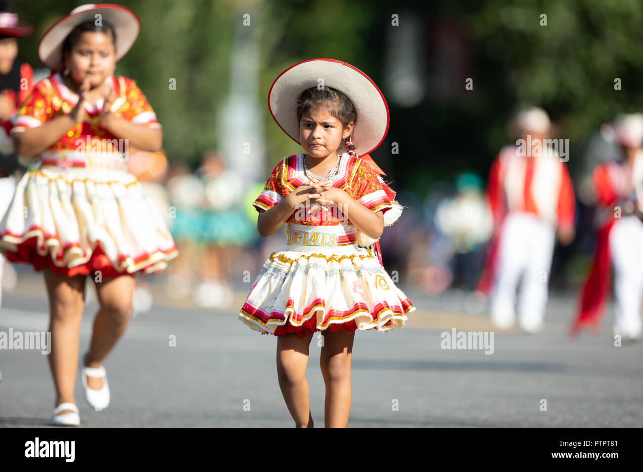 Washington, D.C., USA - September 29, 2018: The Fiesta DC Parade, Young Bolivian girl wearing traditional clothing going down the street during the pa Stock Photo