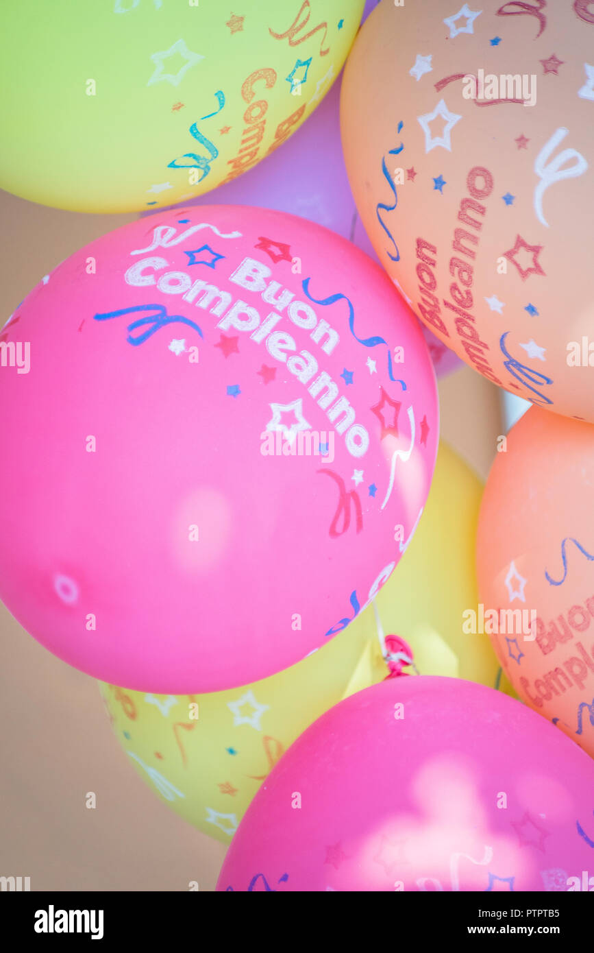 Close-up of colourful balloons with 'Buon compleanno' ( Happy birthday in Italian) written on it. Stock Photo