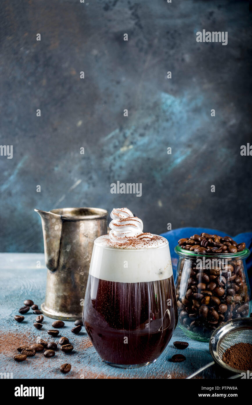 Autumn espresso drink ideas, Irish coffee cocktail with whipped cream and cocoa, blue concrete background copy space Stock Photo