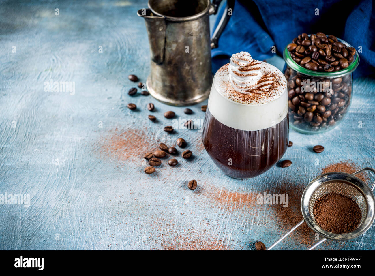 Autumn espresso drink ideas, Irish coffee cocktail with whipped cream and cocoa, blue concrete background copy space Stock Photo