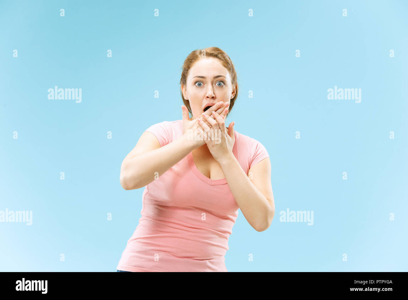 I'm afraid. Fright. Portrait of the scared woman. Business woman standing isolated on trendy blue studio background. Female half-length portrait. Human emotions, facial expression concept. Stock Photo