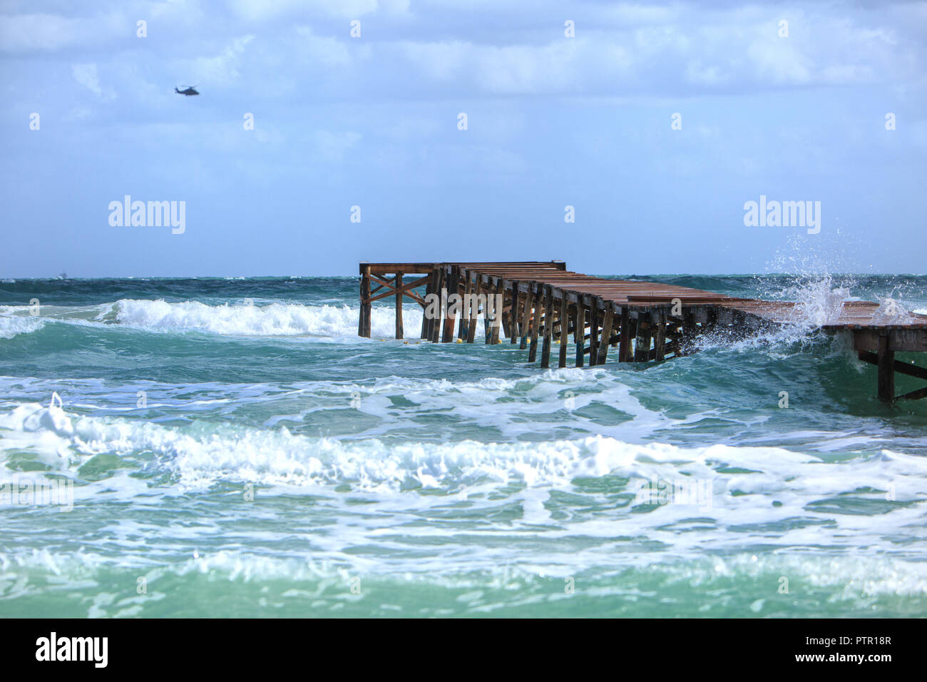 Storm Waves at the beach of Playa de Muro, Europe Spain North Mallorca Playa de Muro, long wooden jetty in the bay of Alcudia during a storm Stock Photo