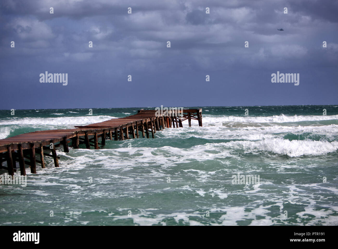 Storm Waves at the beach of Playa de Muro, Europe Spain North Mallorca Playa de Muro, long wooden jetty in the bay of Alcudia during a storm waves Stock Photo
