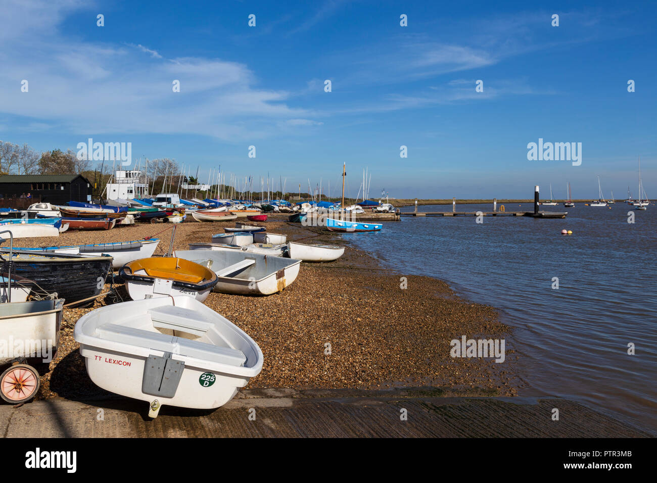 Dinghies and Sailing Boats on the Beach of the River Ore Separating Orford from Orford Ness on a Very Sunny October Afternoon Stock Photo