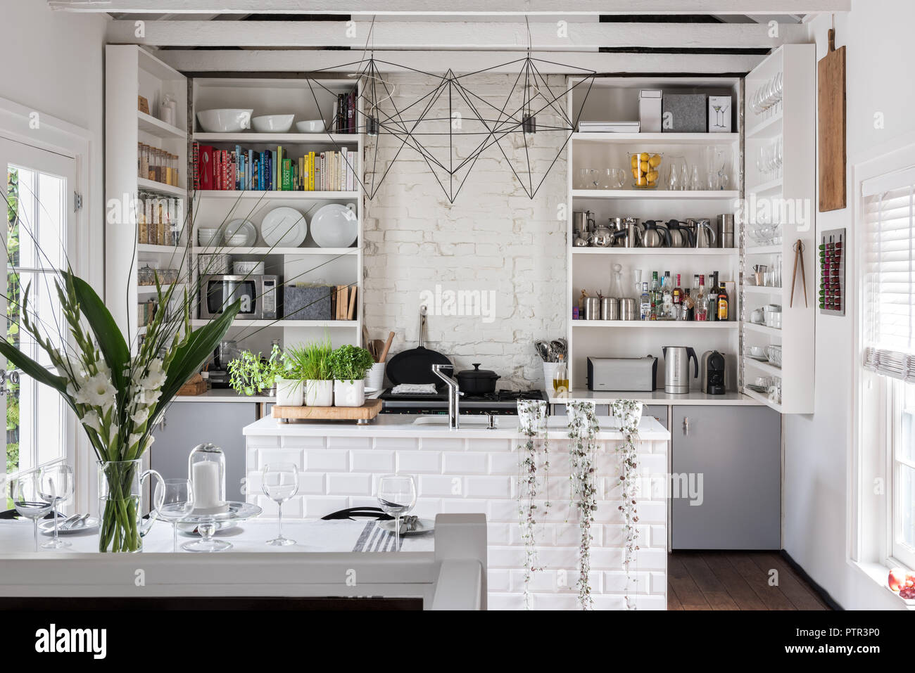 Whitewashed kitchen with bespoke space-saving cupboard doors Stock Photo