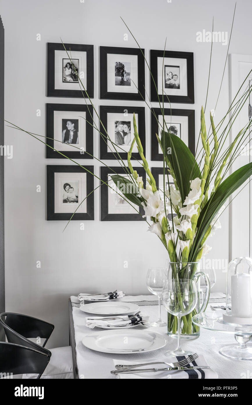 Cut flowers and framed portraits with dining table Stock Photo