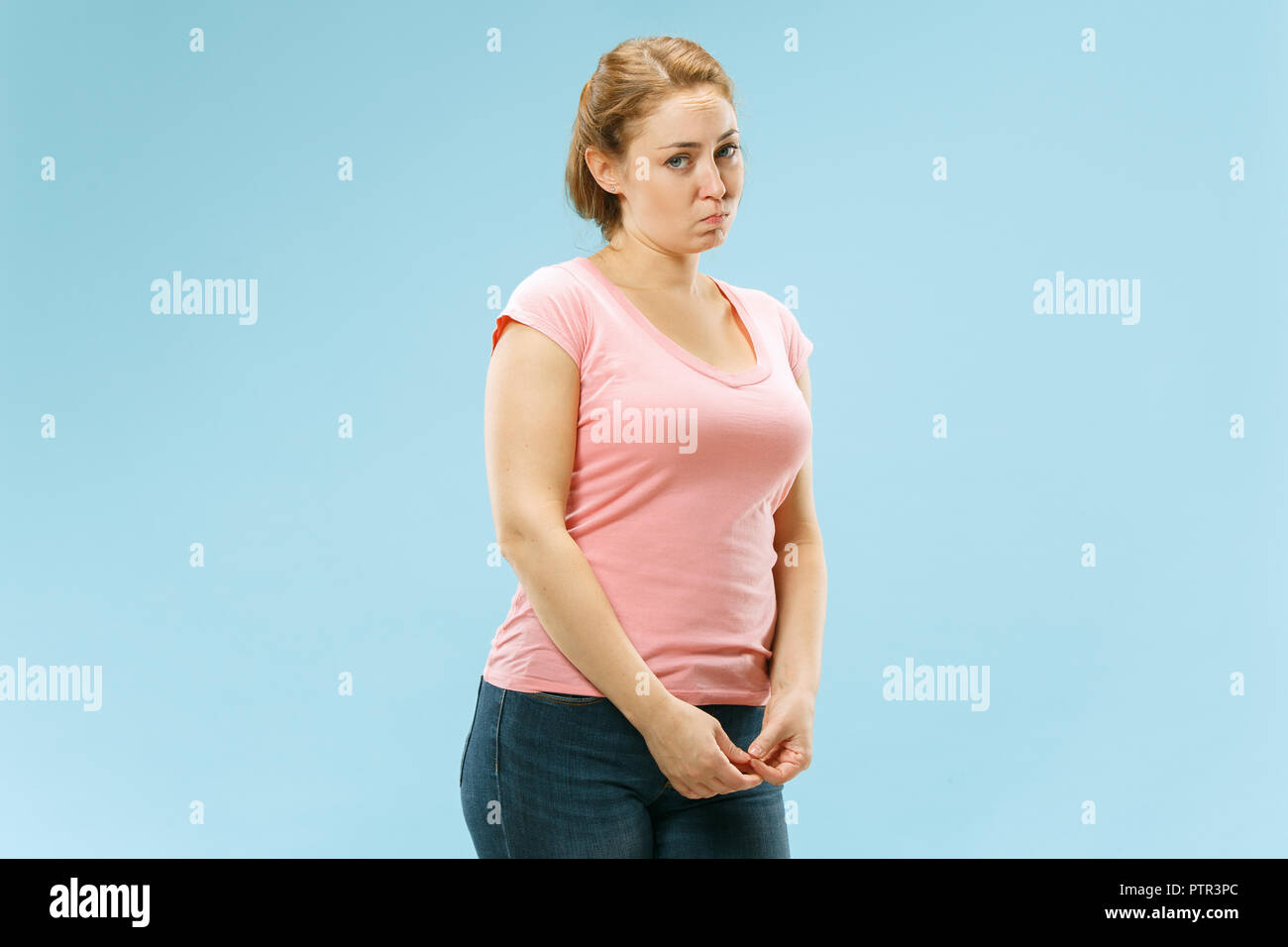 Why is that. Beautiful female half-length portrait isolated on trendy blue studio backgroud. Young emotional surprised, frustrated and bewildered woman. Human emotions, facial expression concept. Stock Photo