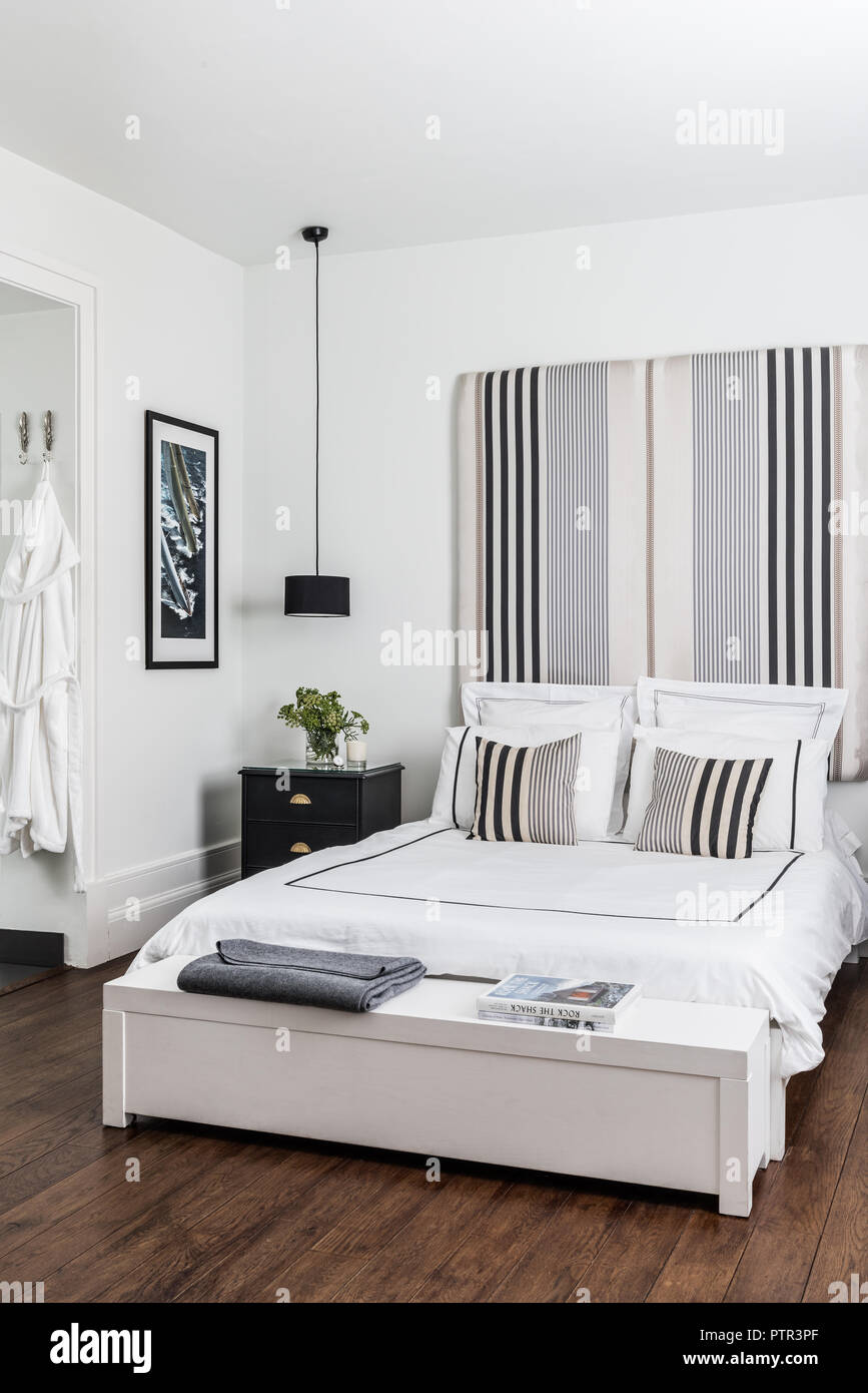 Double bed with headboard covered in Ariana Parini fabric from the Designers Guild with bed linen from The White Company Stock Photo