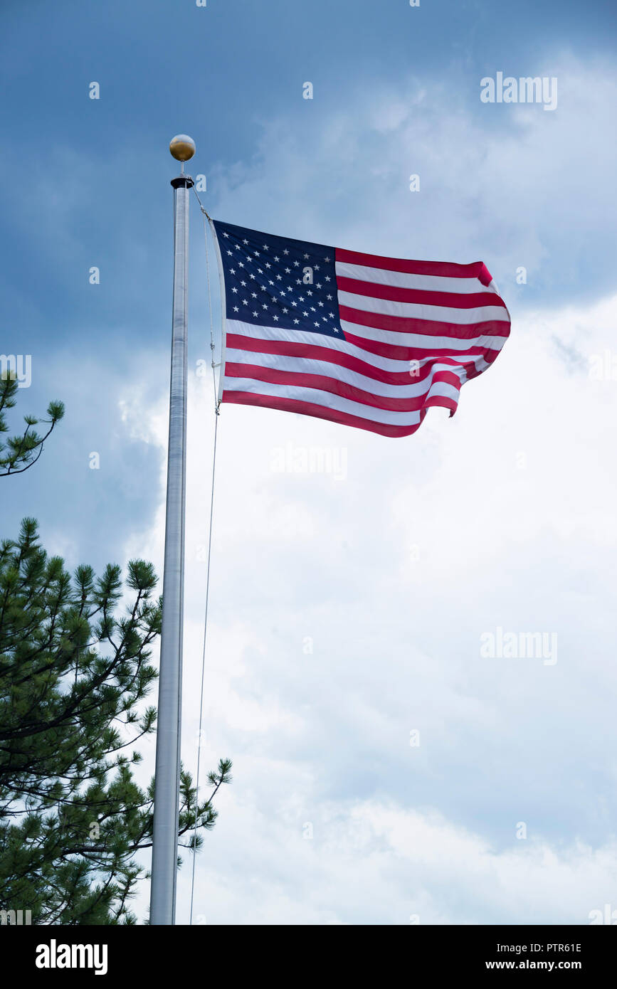 American flag also called the Stars and Stripes or Old Glory flying at full mast on flag pole in United States Stock Photo