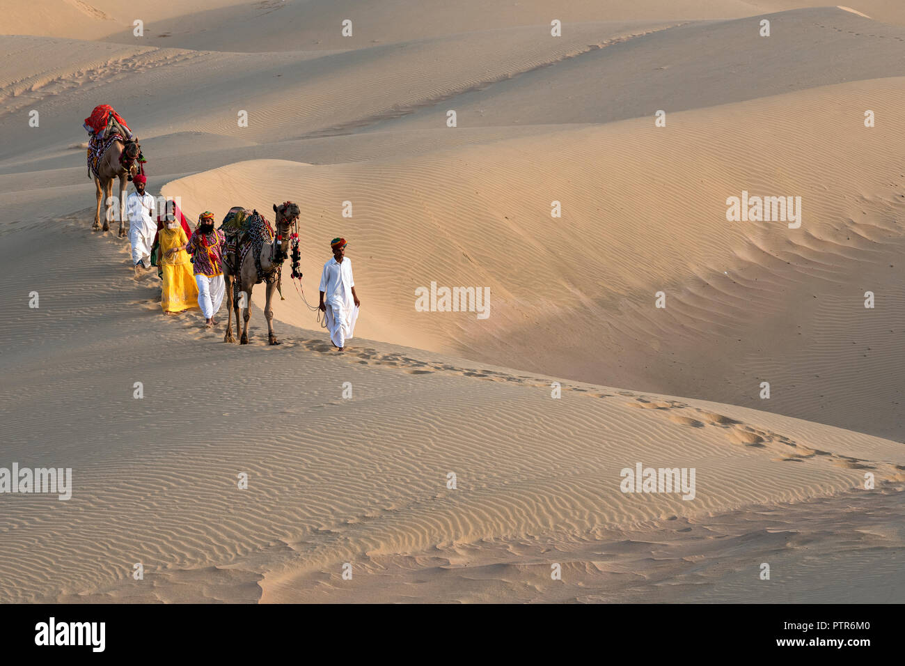The image of Rajasthani trditional man and woman in sand dunes, Jaisalmer, Rajasthan, India Stock Photo