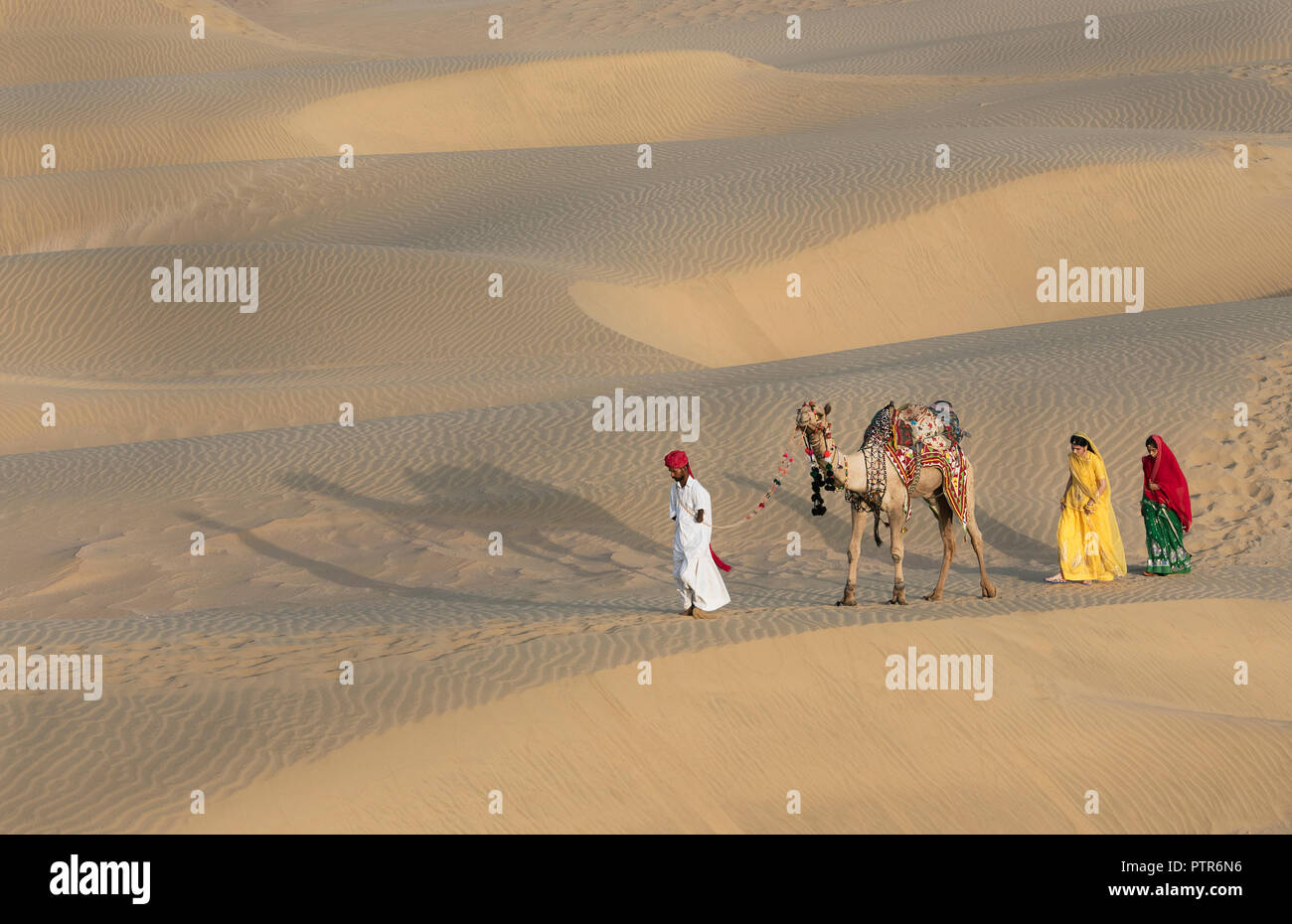 The image of Rajasthani trditional man and woman in sand dunes,  Jaisalmer, Rajasthan, India Stock Photo