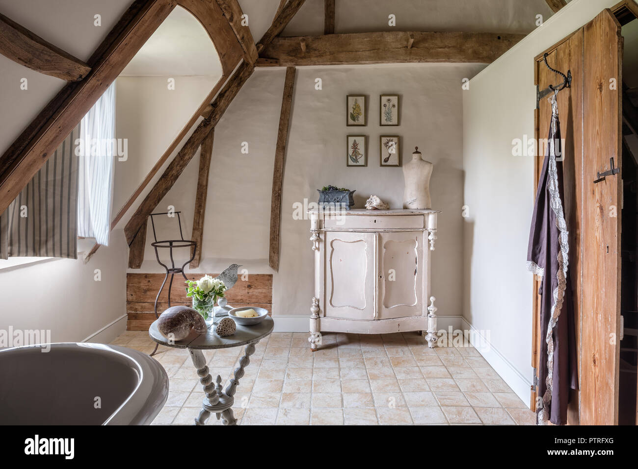 Mannequin on sideboard with botanical prints in restored 16th century farmhouse bathroom Stock Photo