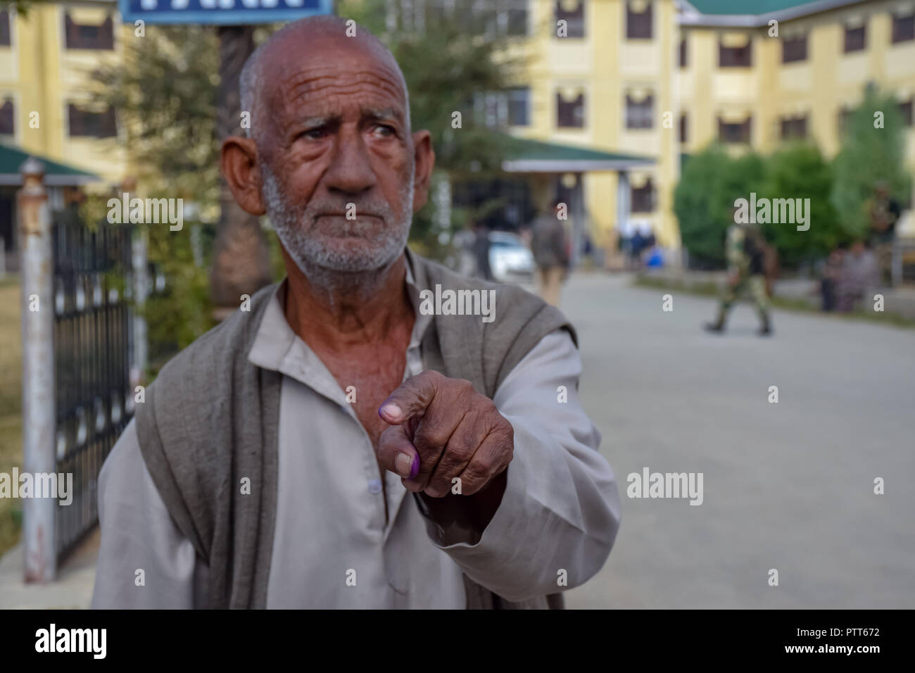 October 10, 2018 - Baramulla, Jammu & Kashmir, India - An elderly man seen showing his ink marked finger after casting his vote in Sumbal polling station during the elections..Second phase of urban local body (ULB) Elections held in Jammu and Kashmir. Summer Capital of Indian controlled Kashmir, Srinagar. This had the lowest turnover of voters during the Local elections. (Credit Image: © Idrees Abbas/SOPA Images via ZUMA Wire) Stock Photo