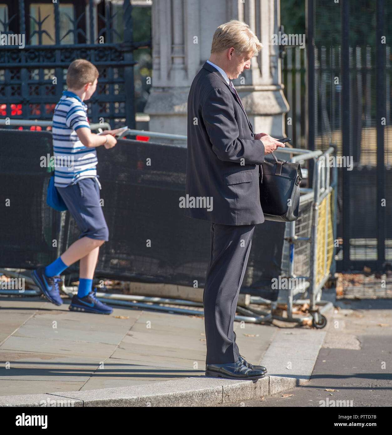 Parliament Square, London, UK. 10 October, 2018. Jo Johnson MP, Minister of State for the Department of Transport and brother to Boris Johnson, checking his phone outside Parliament at mid-day. Credit: Malcolm Park/Alamy Live News. Stock Photo