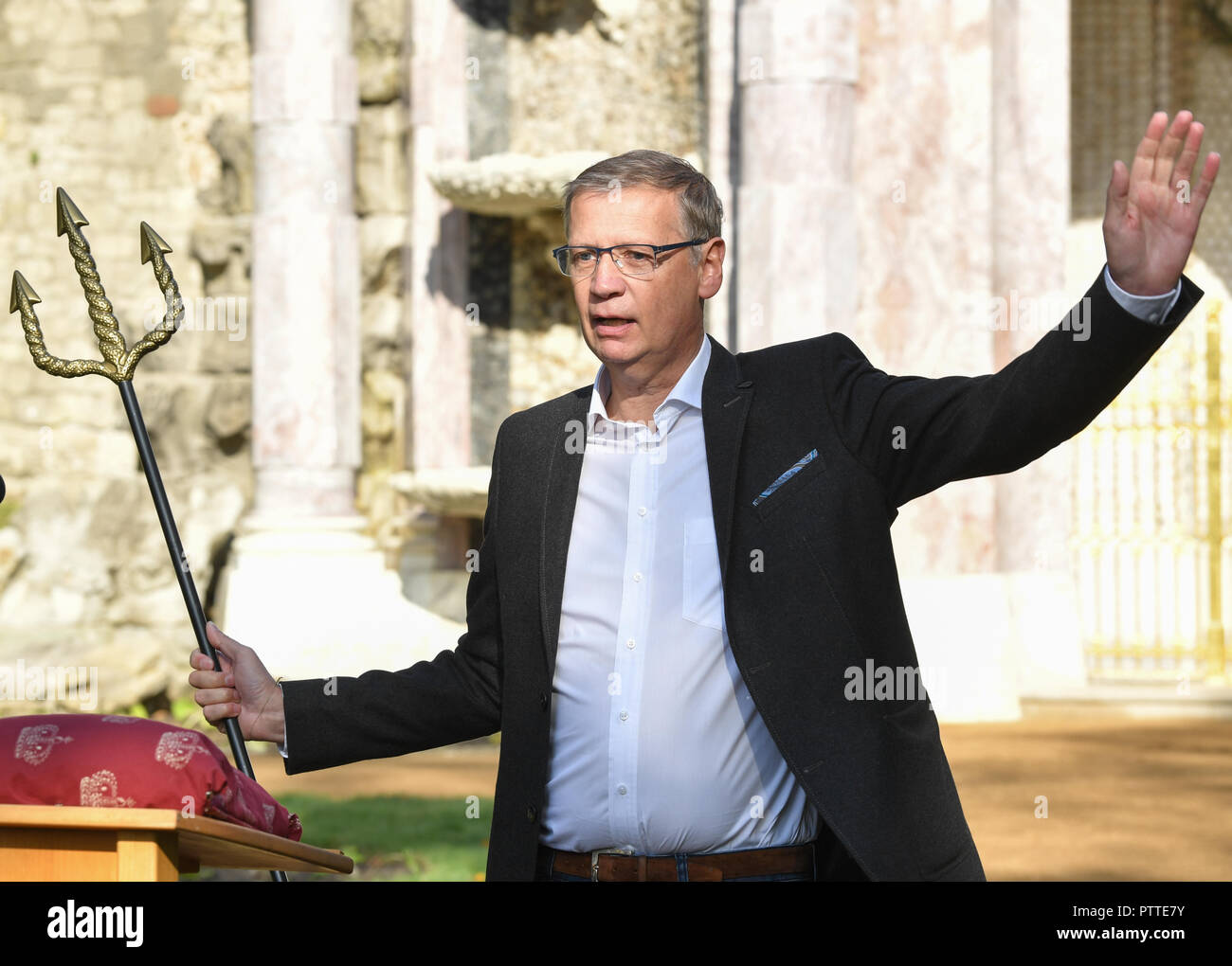 Potsdam, Brandenburg. 10th Oct, 2018. The television presenter Günther Jauch at the opening of the restored Neptungrotte in Sanssouci Park. He uses a Neptune Trident to signal the start of the waterfalls that are part of the structure. The moderator and his wife had donated for the restoration of the grotto. Credit: Jens Kalaene/dpa-Zentralbild/dpa/Alamy Live News Stock Photo