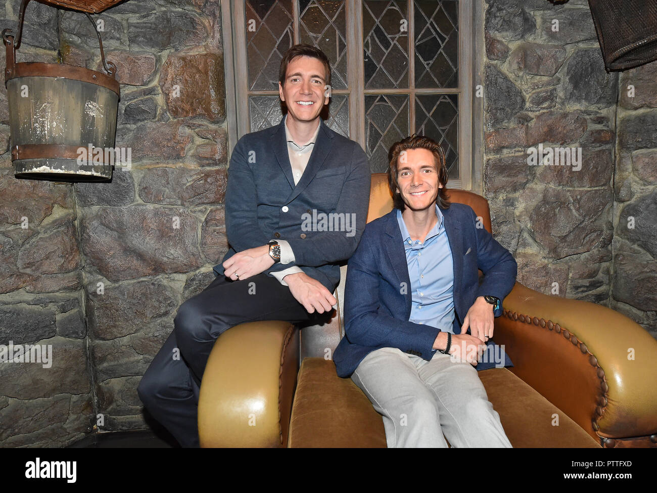 Potsdam, Brandenburg. 11th Oct, 2018. The actors James (r) and Oliver Phelps who sit in the Harry Potter films The Weasley Twins at the press conference for the "Harry Potter" exhibition in the set of Hagrid's hut. The exhibition, which opens for visitors on Saturday (13.10.2018) in the Filmpark Babelsberg, shows costumes and complete sets of the film series. Credit: Bernd Settnik/dpa-Zentralbild/dpa/Alamy Live News Stock Photo