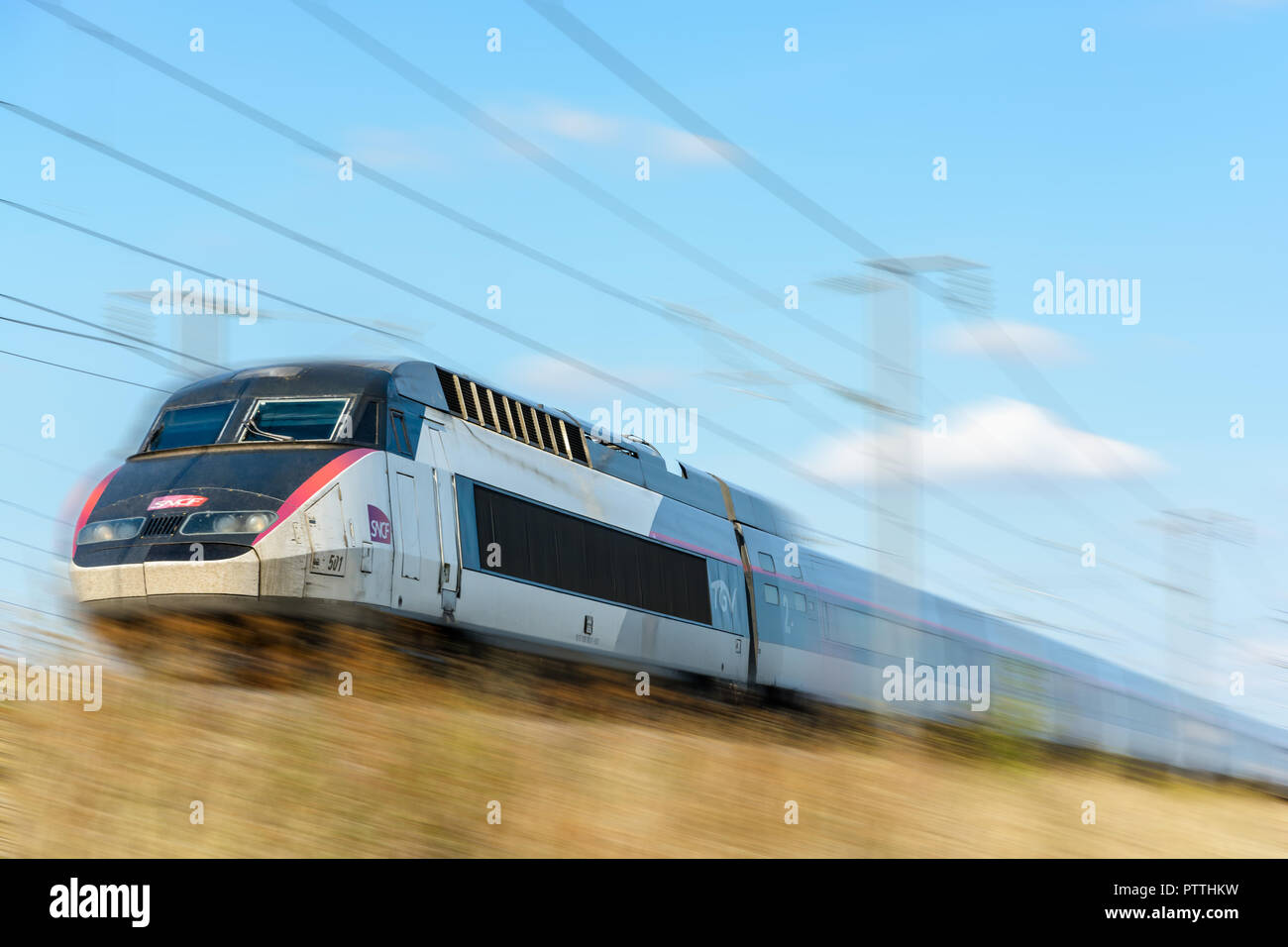 A TGV high-speed train in Carmillon livery from french company SNCF driving at full speed on the East European high-speed railway (with motion blur). Stock Photo