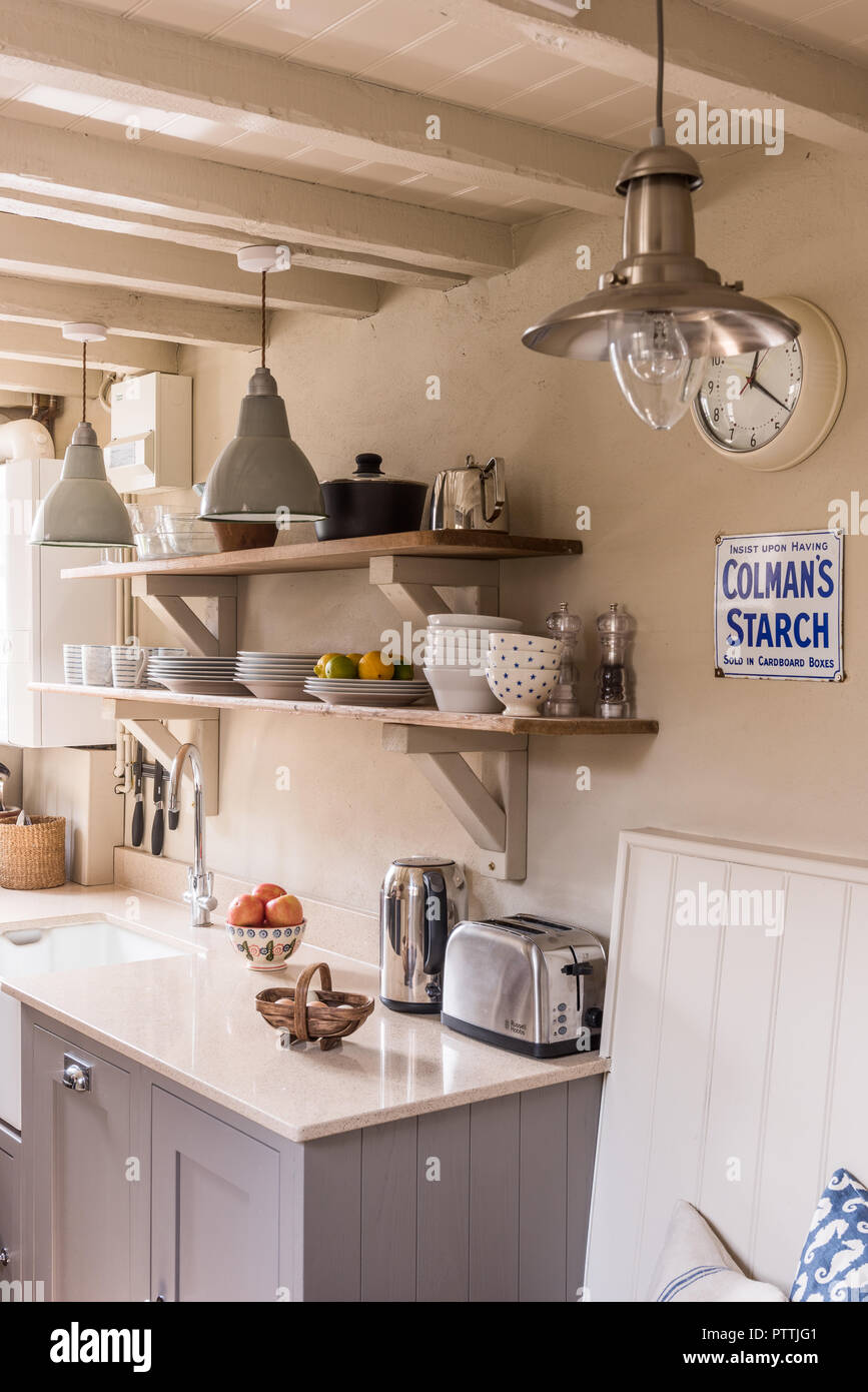 Coastal kitchen with open shelves and antique pendant light Stock Photo