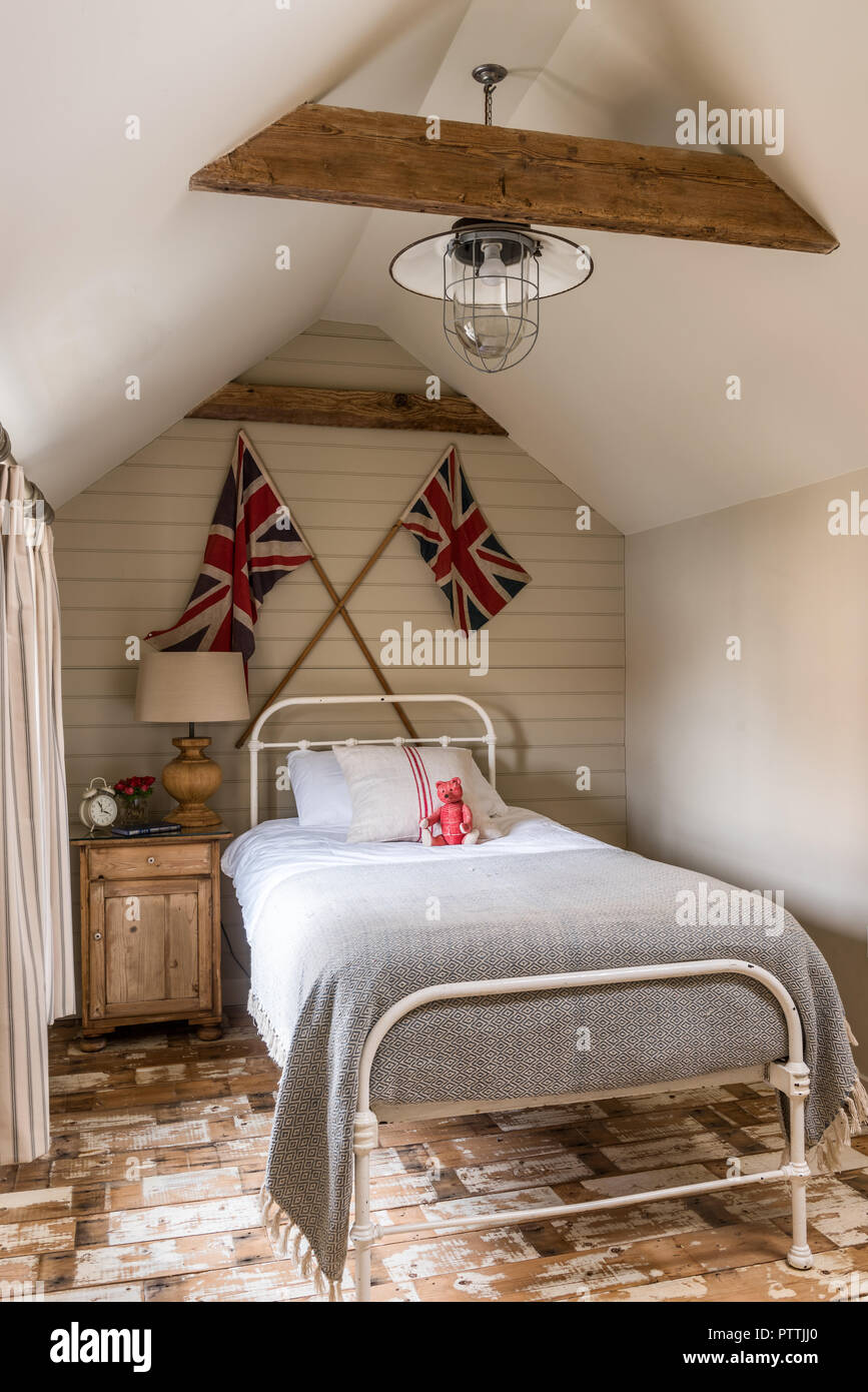 Single bed with Union Jacks and reclaimed wooden floorboards Stock Photo