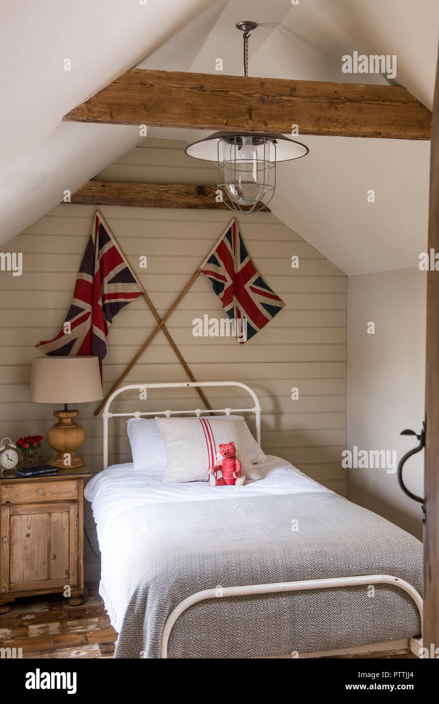 Single bed with Union Jacks and reclaimed wooden floorboards Stock Photo