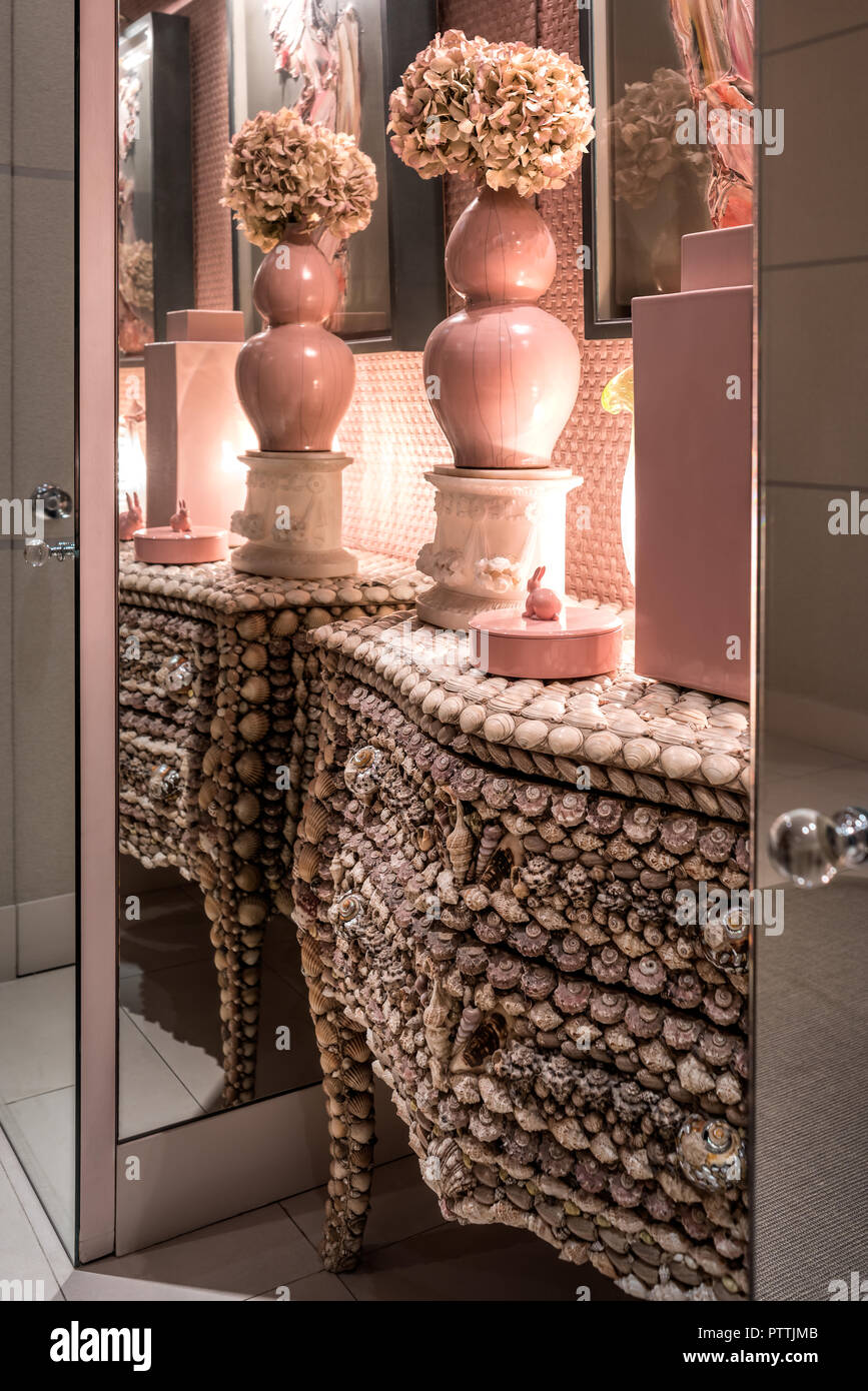 Entrance hall papered in design by Nina Campbell with ceramic pot by Joe Tilson and French shell-covered antique chest Stock Photo