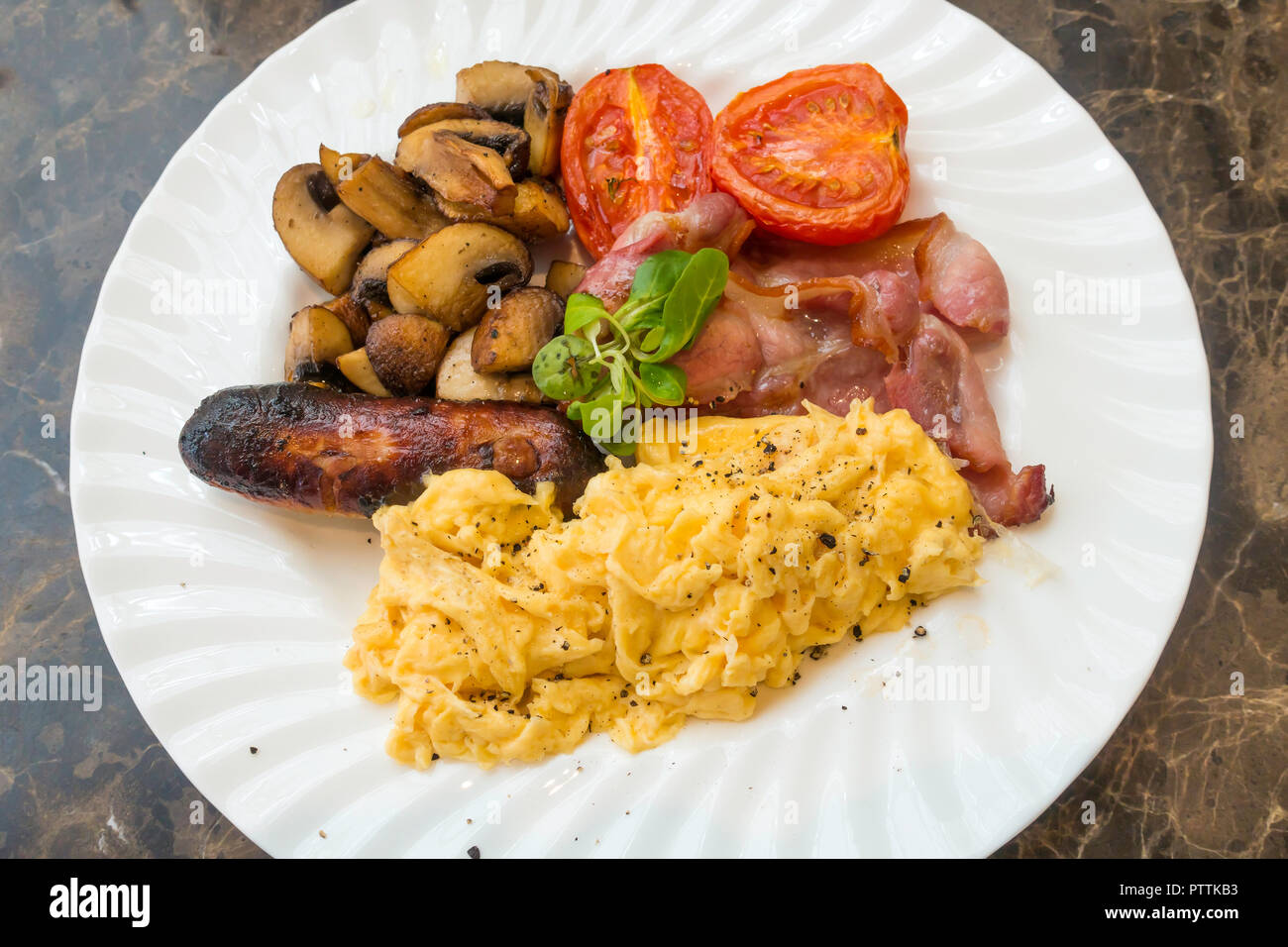 Cafe meal an English Breakfast bacon scrambled egg sausage and fried tomato and mushrooms served in Yorkshire Stock Photo