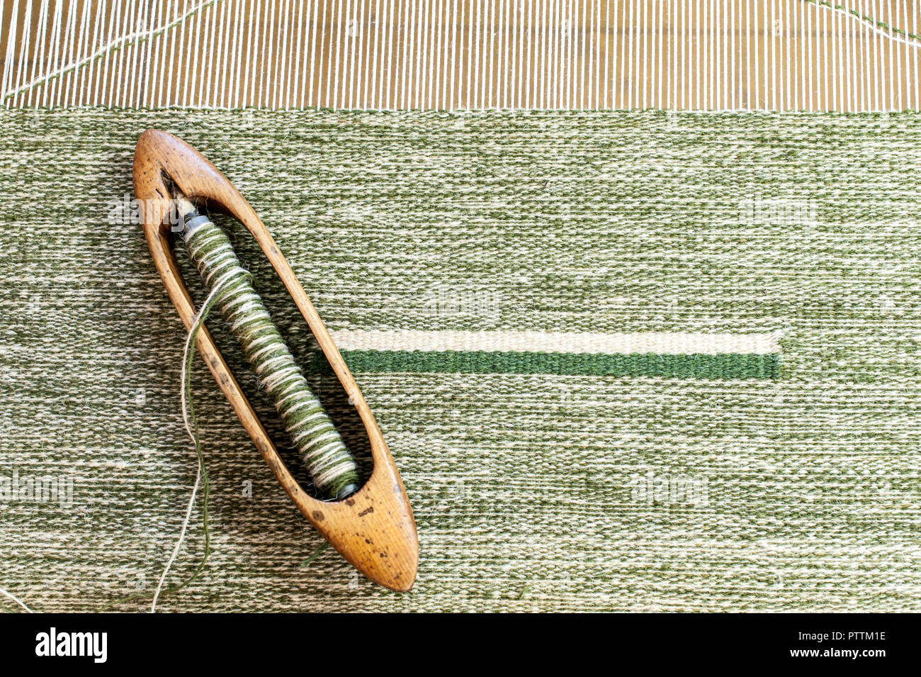 Weaving loom and shuttle on the warp. Weaving background and sample