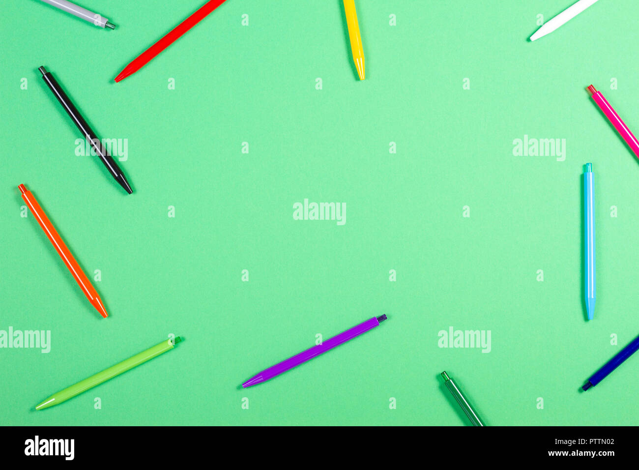 Colorful pens frame on green background Stock Photo