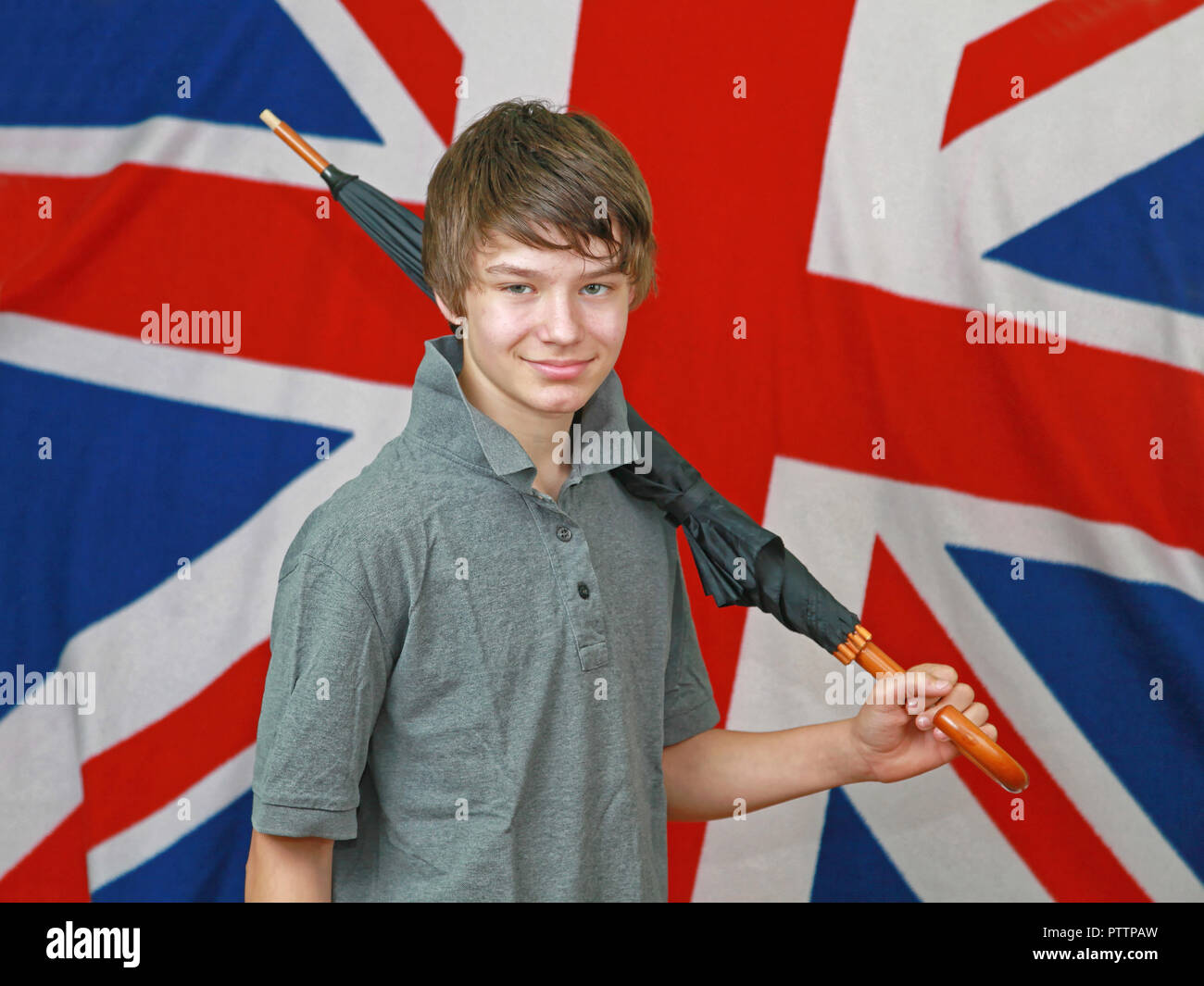 Young British Boy With Umbrella in Front of Union Jack Flag Stock Photo