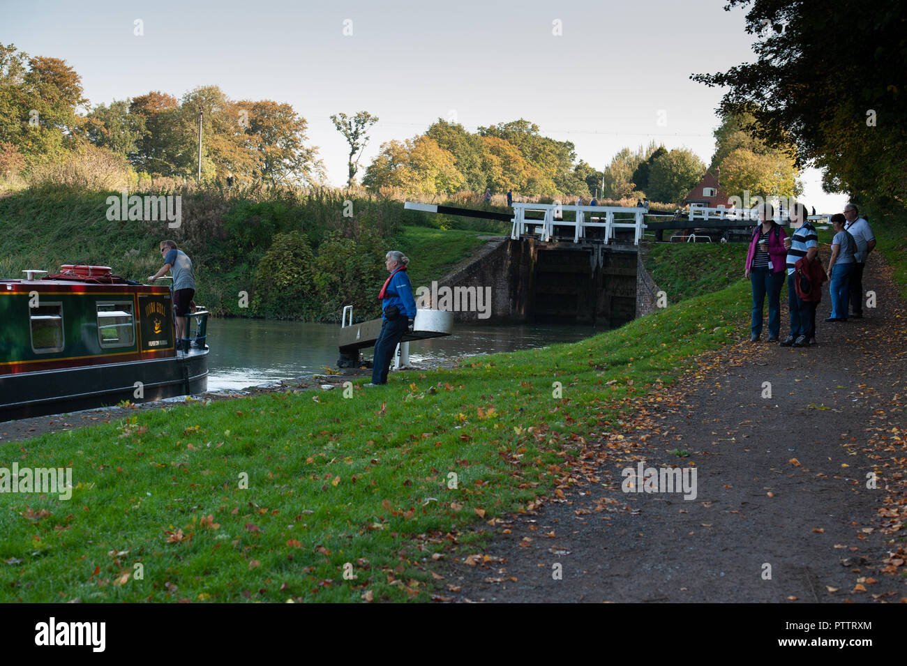 'Gonggozlers' watching Volunteer Lock Keepers helping a narrowboat through the Caen Hill Flight on the Kennet and Avon Canal, Devizes, Wiltshire, UK. Stock Photo